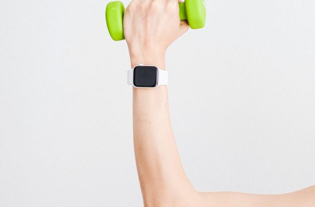 person-wearing-white-apple-watch-while-holding-green-4482936